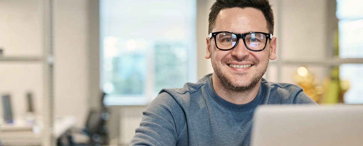 Man at desk smiling at camera