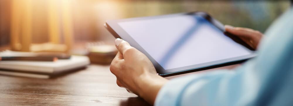 Hands holding a tablet, representing a tech-related raffle prize