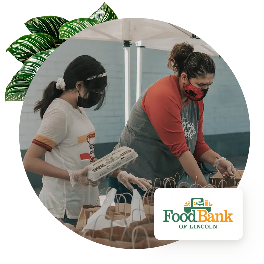 Women at the food bank of Lincoln packing bags of food.
