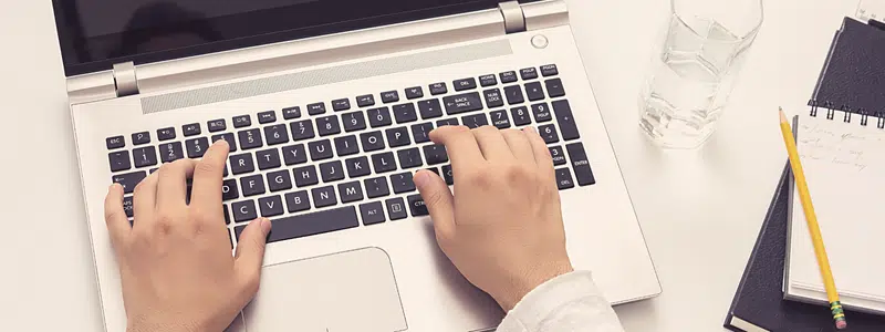 Hand on keyboard typing a tribute notification to a donor.