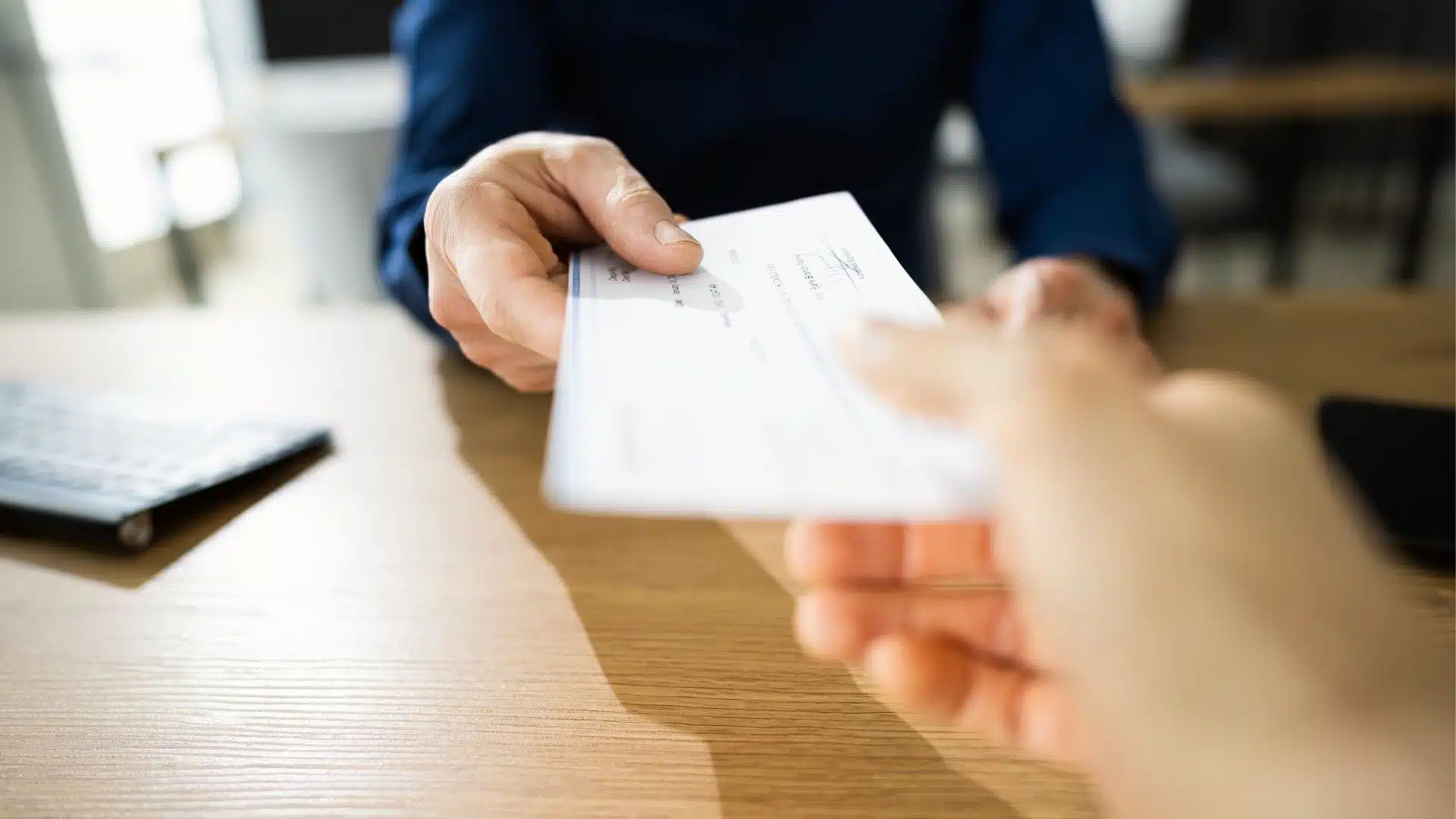 A person is handing over a check to another person