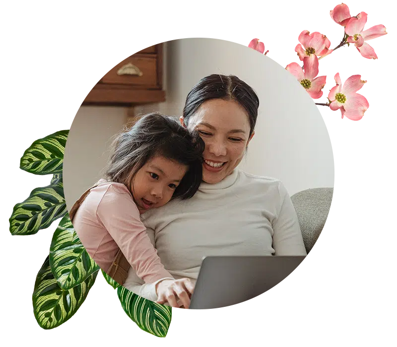 Mom and daughter looking at computer and smiling.