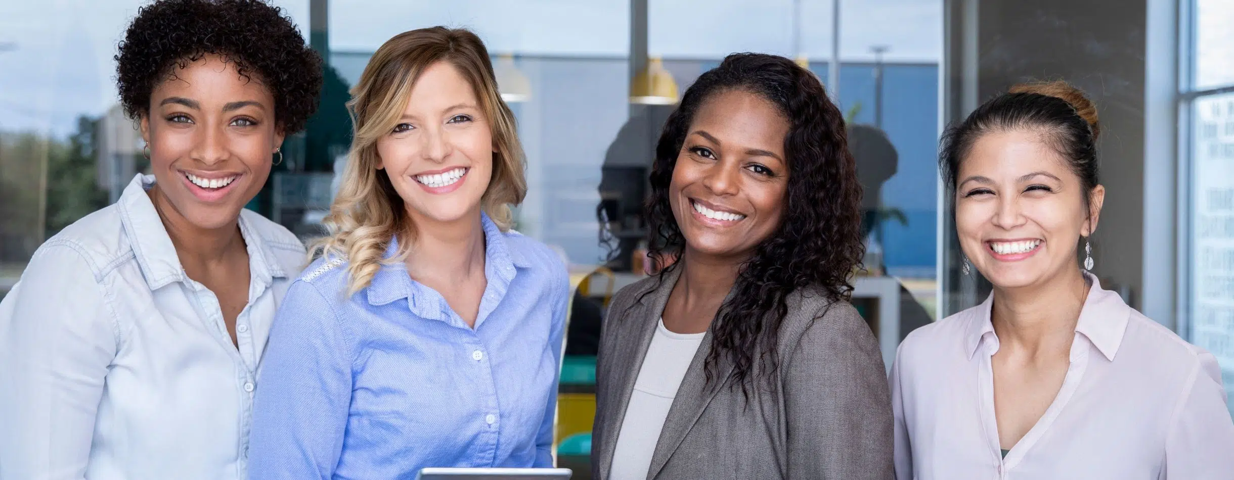 Women smiling, like the ones the YWCA provides services for.