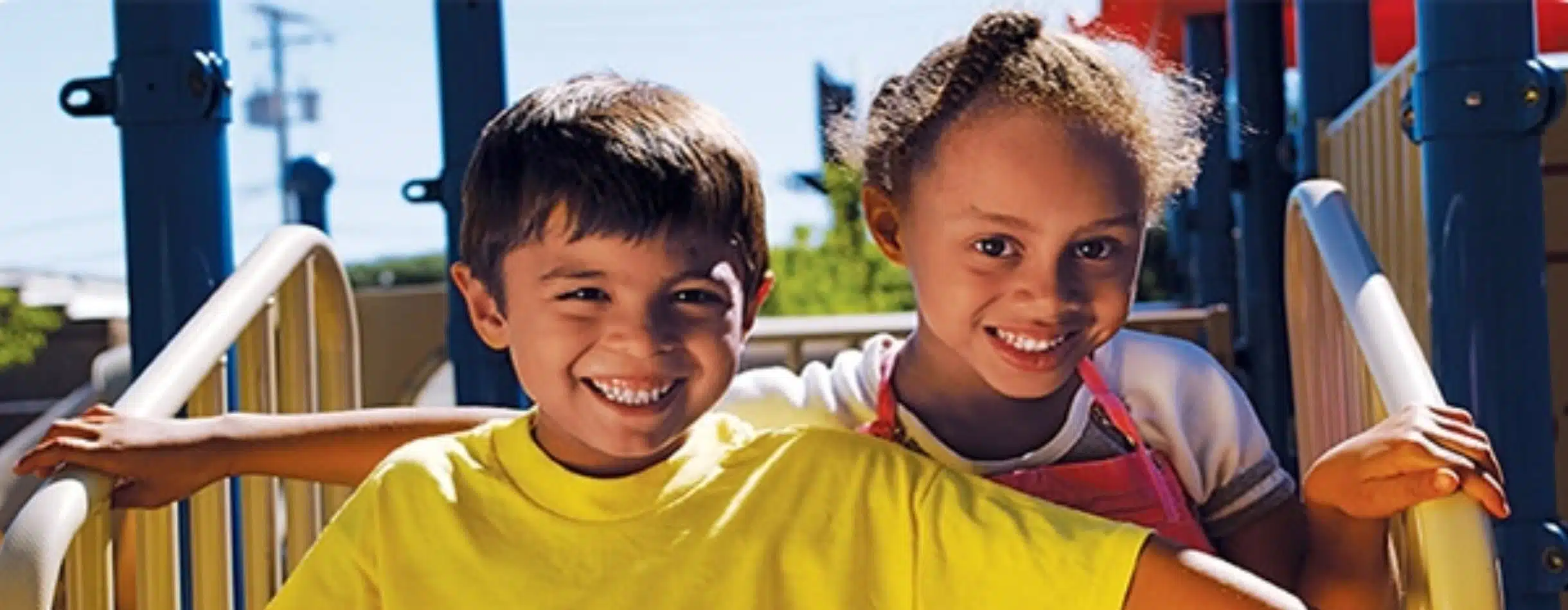 image of two smiling children on a playground